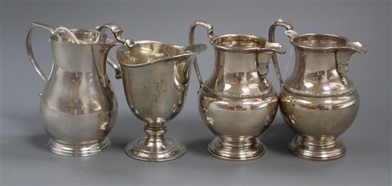 A Georgian style sparrow beak cream jug, a helmet-shaped cream jug and a pair of baluster-shaped cream jugs, 20.5oz